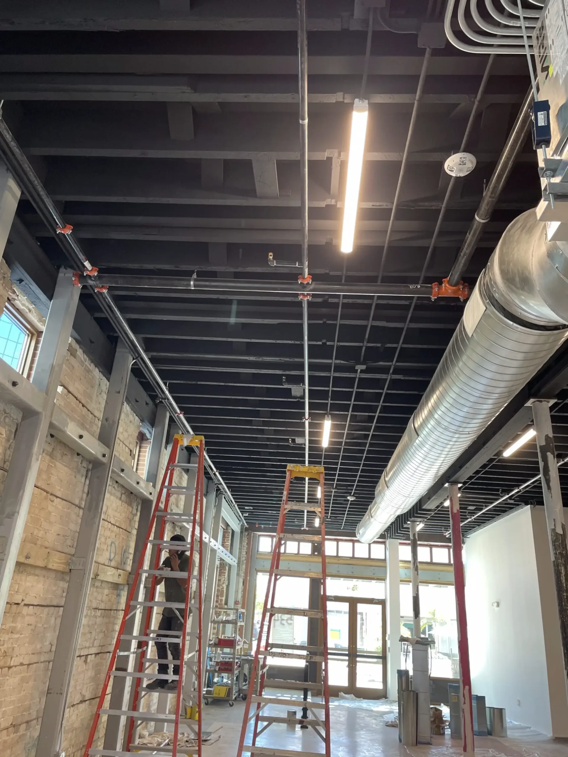 Industrial building undergoing detailed ceiling painting completed by Precision Painters